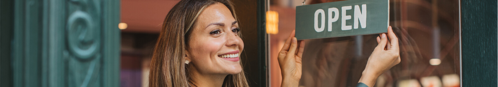 Woman flipping over OPEN sign