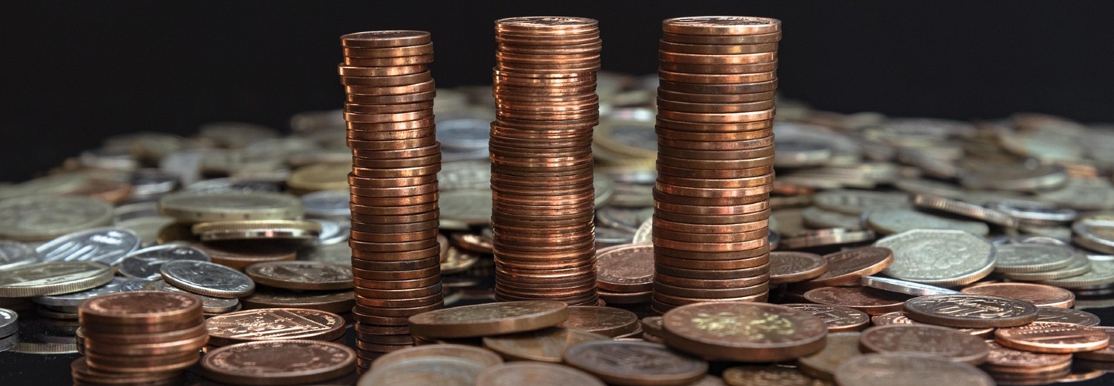 3 stacks of coins surrounded by scattered coins